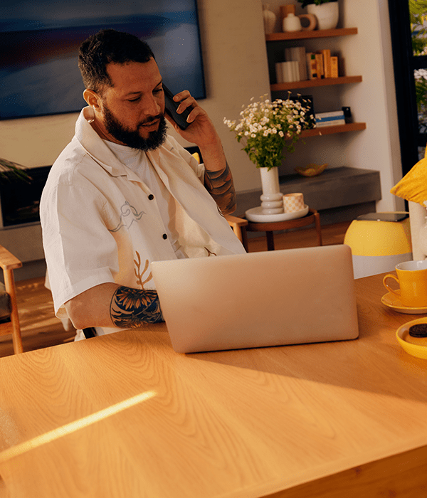 Man uses phone and laptop in his living room