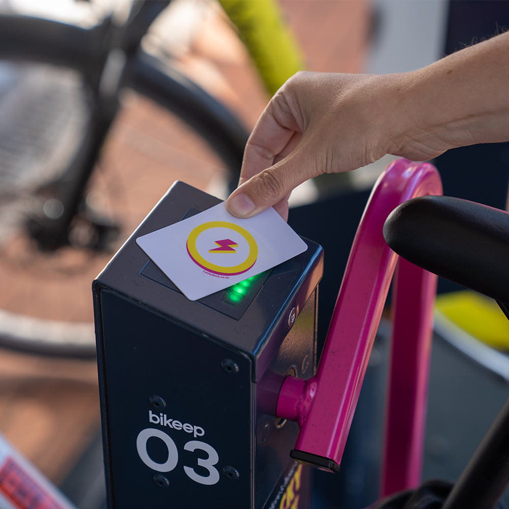 An e.bike rider using a Locky Docky card to unlock a Locky Dock
