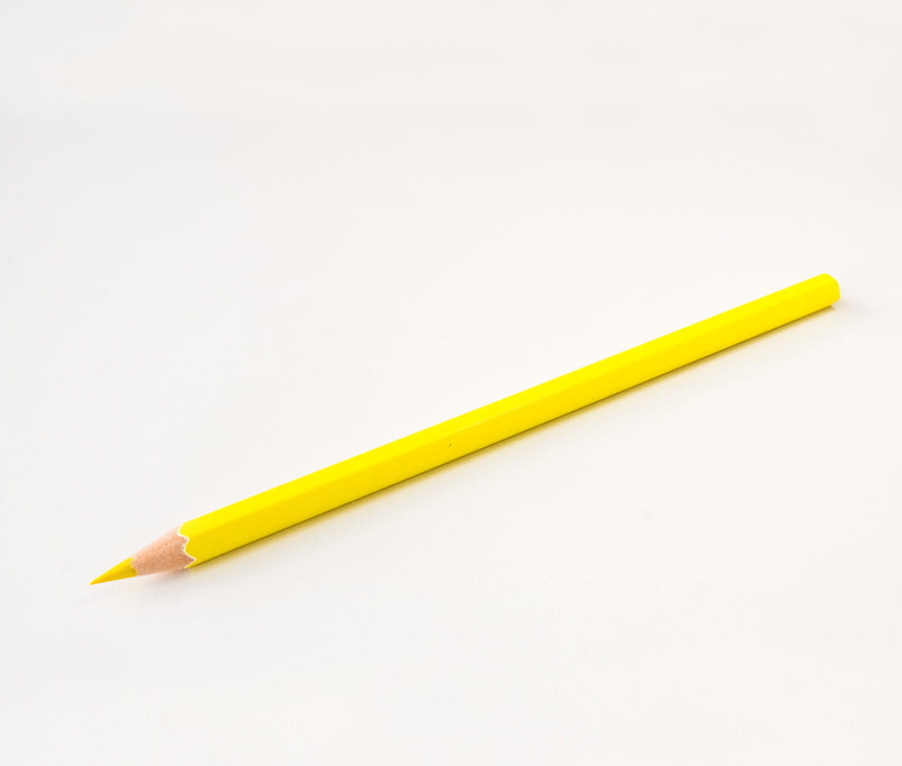 Yellow pencil on a light grey background.