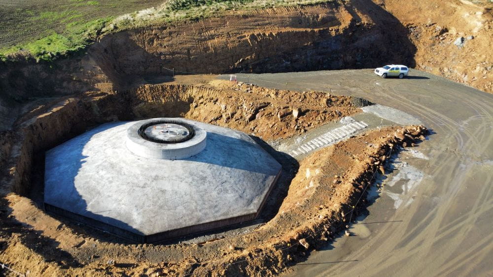 aerial photo of construction of foundations of a wind turbine with motor vehicle in background to provide scale