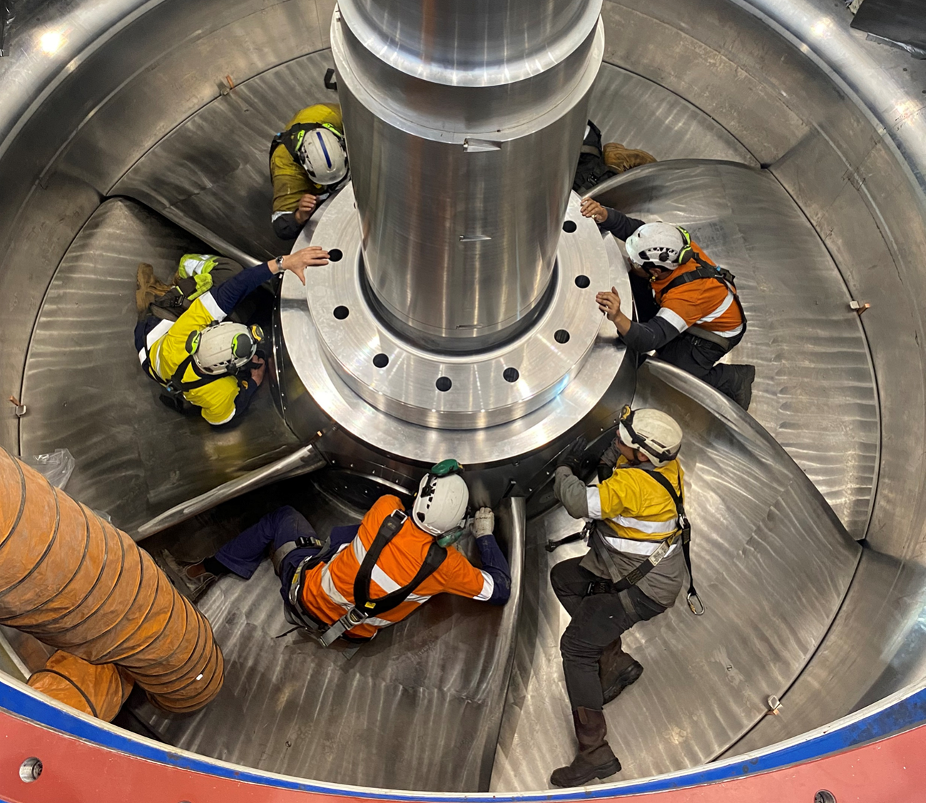 technicians in PPE installing turbine rotor