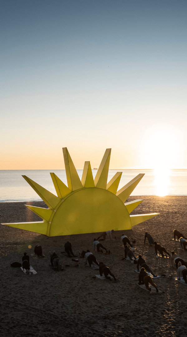 People doing yoga on the beach at sun rise