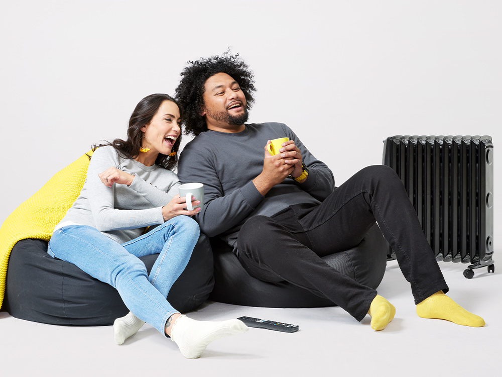 Couple next to oil heater at home in winter