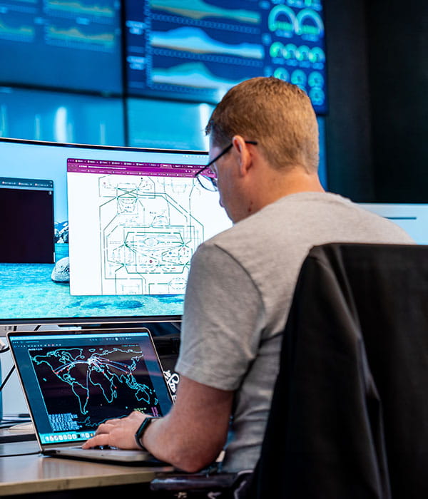 Man at network operations centre looking at network configuration.